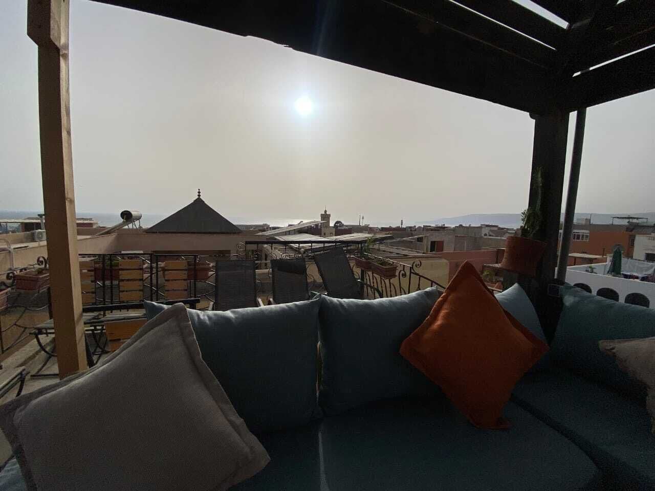 Une terrasse sur le toit, avec un canapé et des fauteuils, d’où l’on peut admirer la vue sur la ville.