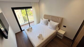 Un dormitorio moderno con una cama grande, una mesita de noche y un televisor.
