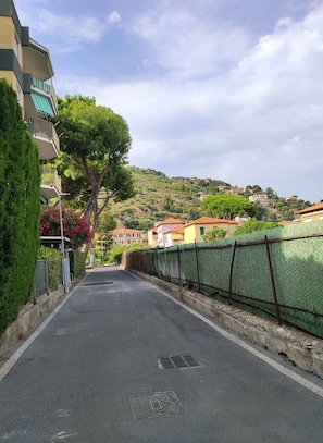A residential street with houses, a green fence, and a clear sky. - 200 meters from the sea, between the French Riviera and Sanremo, with a private garden (Ventimiglia)