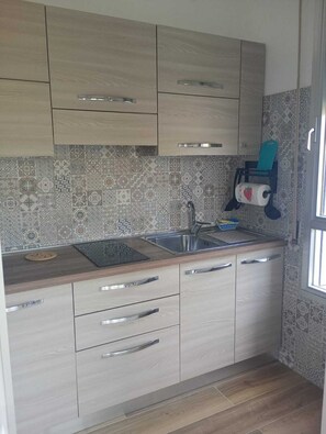 A kitchen with light wood cabinets, a stainless steel sink, and patterned backsplash tiles. - 200 meters from the sea, between the French Riviera and Sanremo, with a private garden (Ventimiglia)
