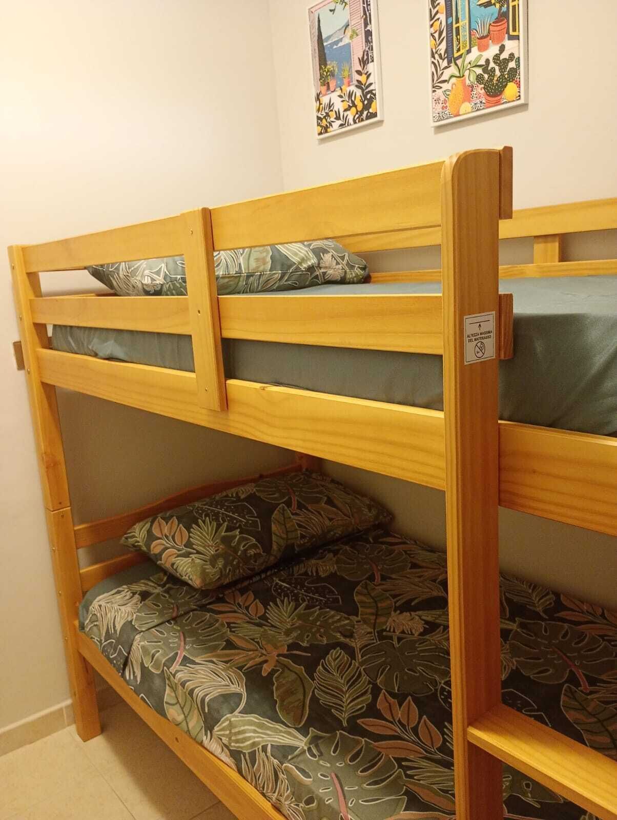 A bunk bed with two levels, each with a pillow and a pillowcase.