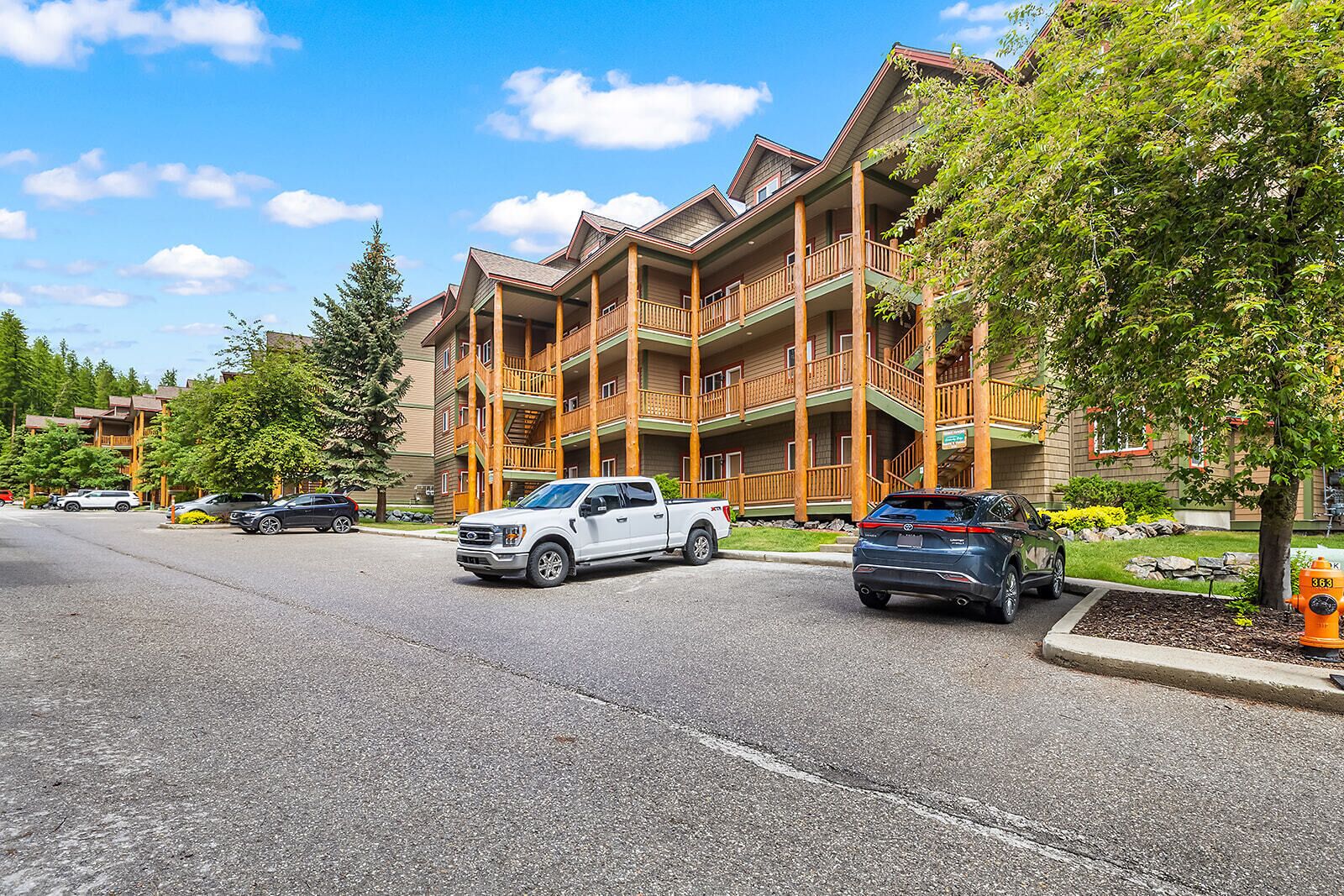 Un hôtel à plusieurs étages doté de balcons, d’un parking et d’une borne d’incendie.