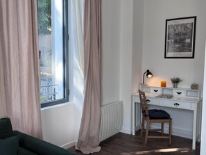 A room with a window, a desk, a chair, and a radiator. - Charming Apartment "La Montagne" for 4 Guests (Évian-les-Bains)
