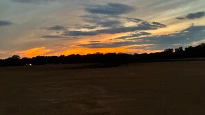 An open field with a sunset sky.