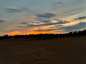 An open field with a sunset sky.