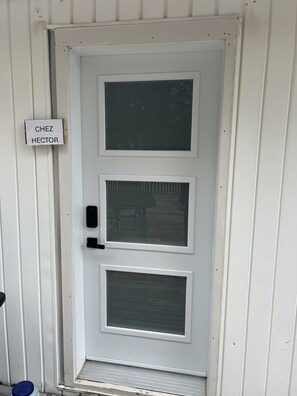 Eine weiße Tür mit einem Schild, auf dem 'CHEZ HECTOR' steht.