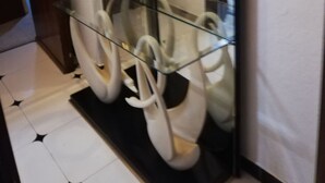 A hallway with a glass display case containing white swan-shaped objects.
