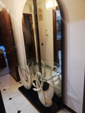 A hallway with a glass display case containing white swan-shaped objects.