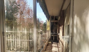 A narrow corridor with a wooden fence on one side and a brick wall on the other.