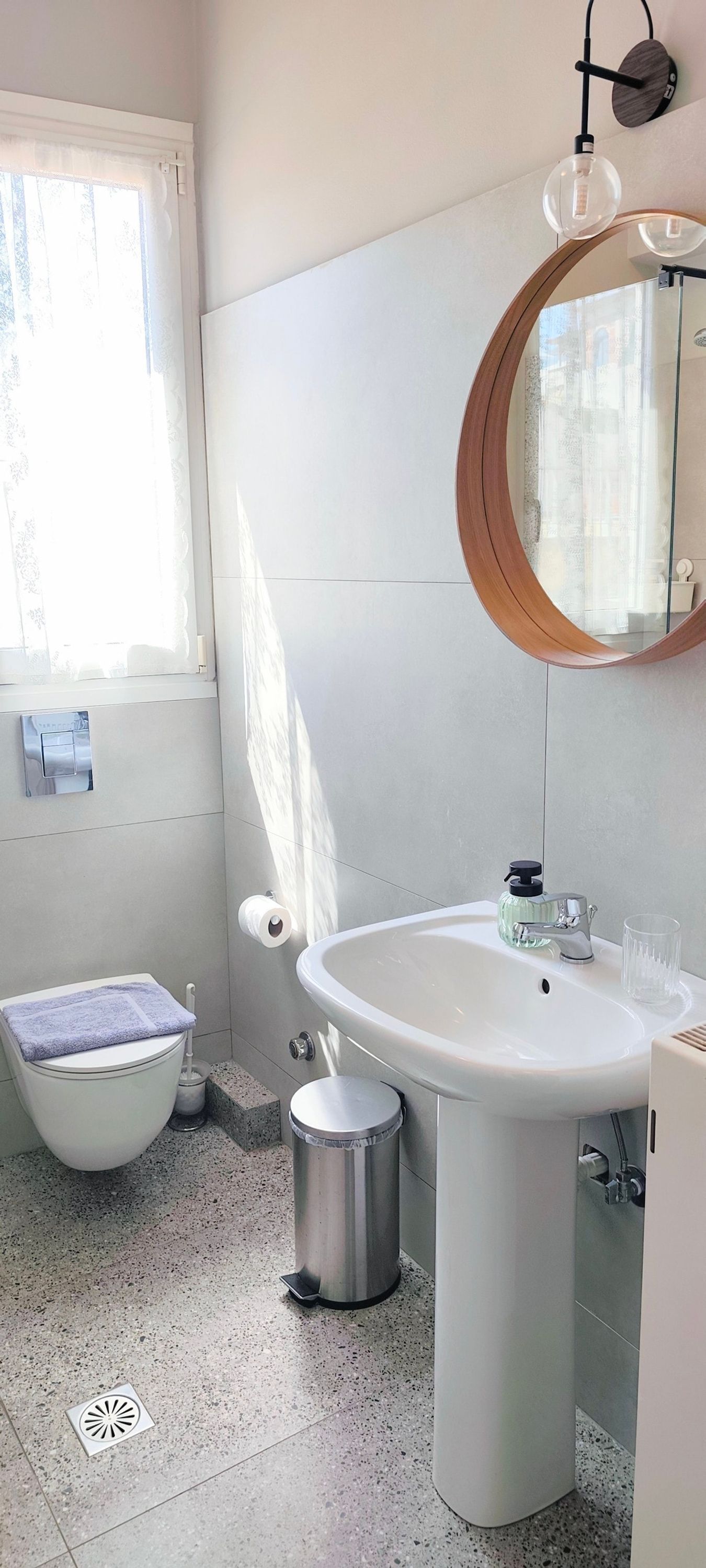 Une salle de bain comprenant des toilettes, un bidet, un lavabo et un miroir avec un cadre en bois.