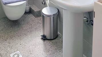 Une salle de bain comprenant des toilettes, un bidet, un lavabo et un miroir avec un cadre en bois.