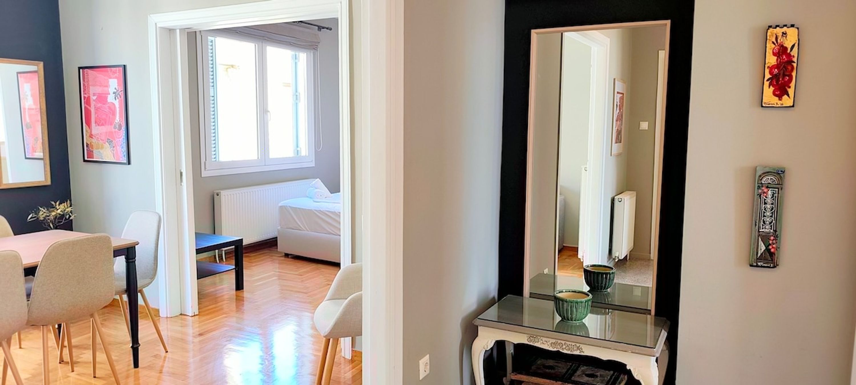 Une pièce comprenant un lit, un bureau, des chaises, un miroir et des œuvres d’art accrochées aux murs.