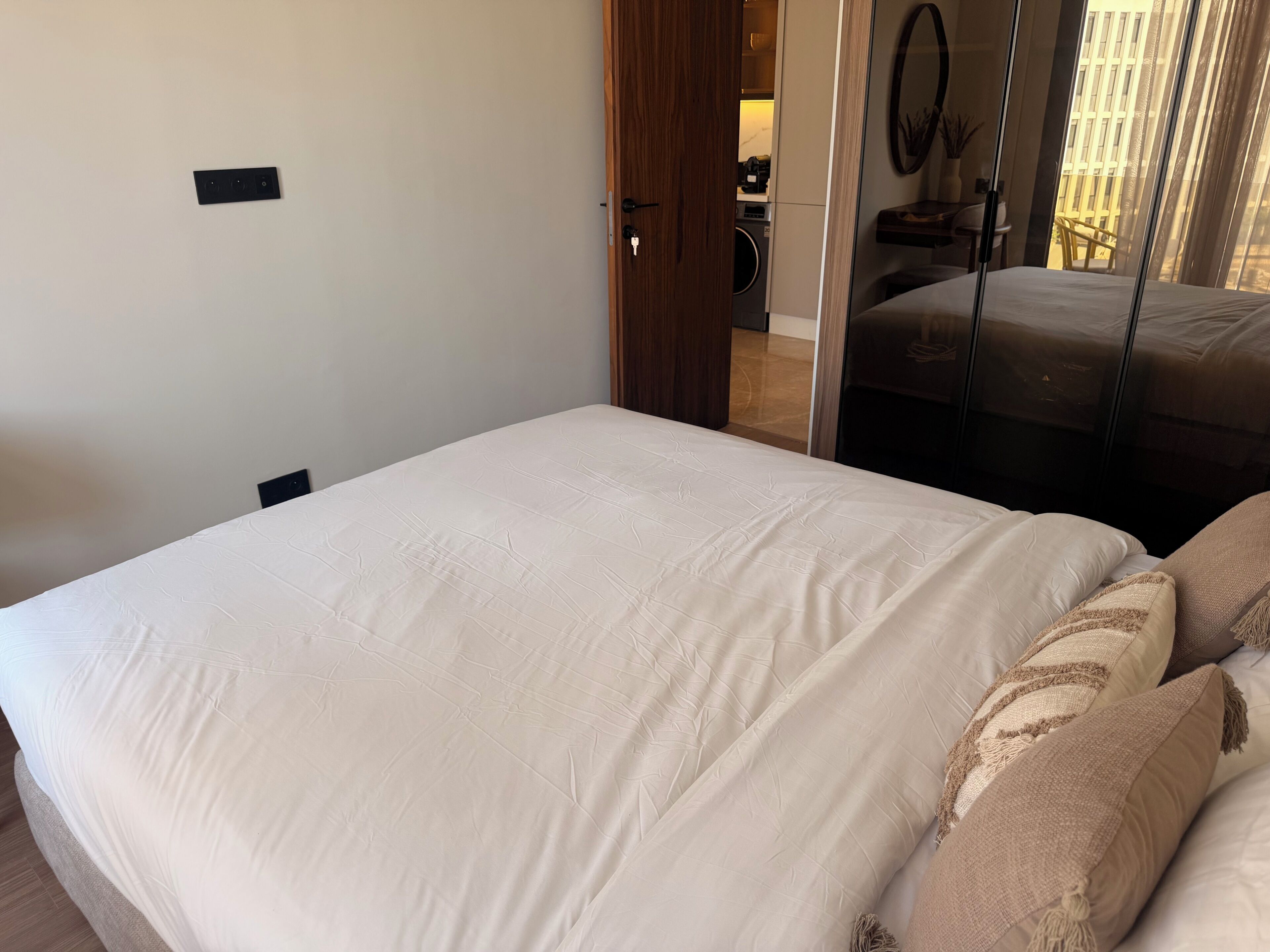 Un dormitorio con cama, una puerta de madera y vistas a un balcón.