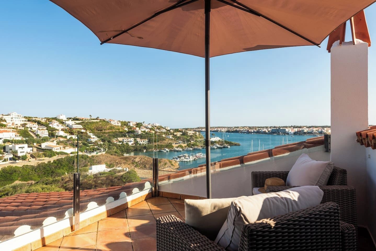 A balcony with a view of a coastal town and marina.