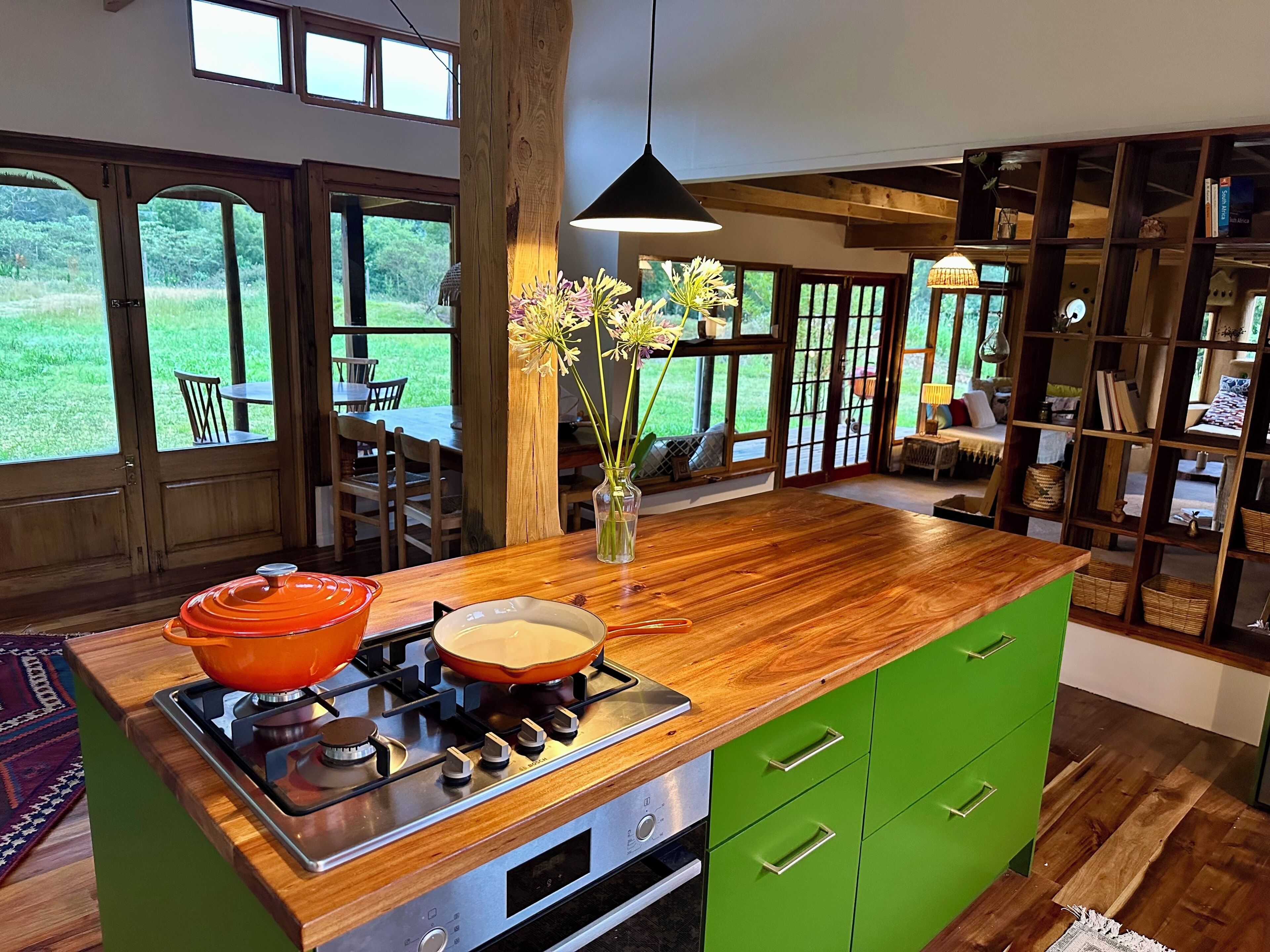 Une cuisine moderne dotée d’un îlot central, d’une cuisinière à gaz et d’une armoire verte.