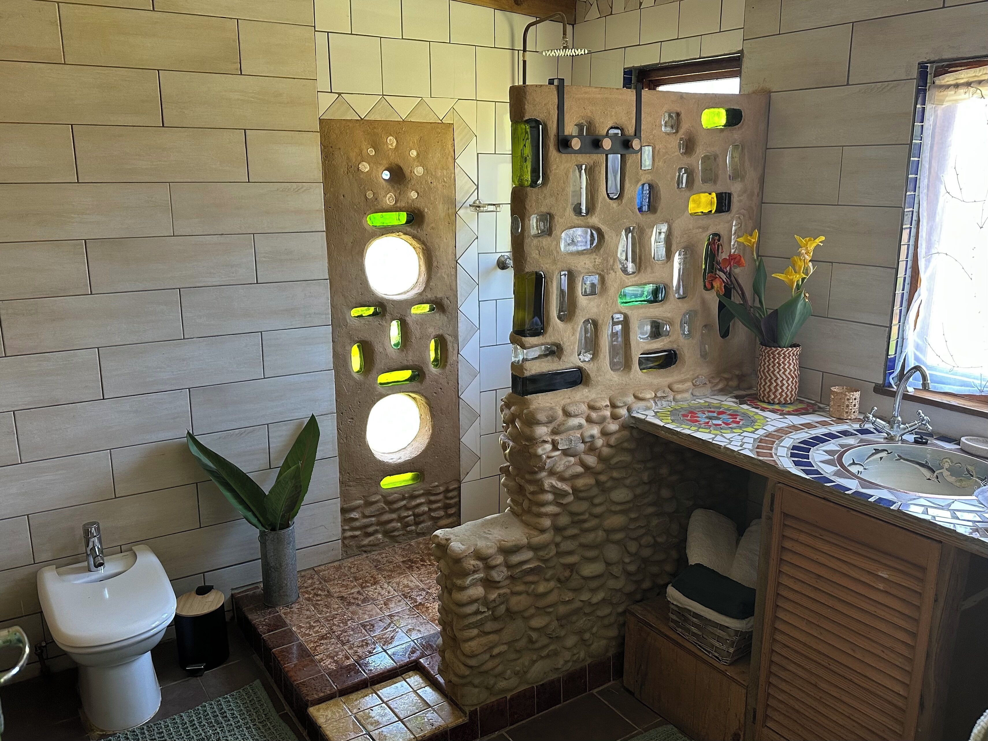 Une salle de bain avec un mur en pierre, un lavabo et des toilettes.