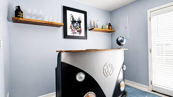 Um quarto com uma van VW camper como peça central, um quadro na parede e um globo em uma prateleira.