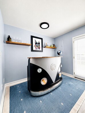 A room with a VW camper van as a central piece of furniture, a framed picture on the wall, and a globe on a shelf. - The Aura, Pool+2BR by Velvet Ditch Villas (Oxford)