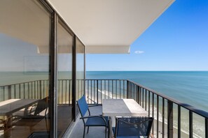 A balcony with a view of the ocean, a table, and two chairs. - Oceanfront Condo with Resort Pool, Hot Tub and Indoor Pool — Garden City Beach, (Garden City Beach)