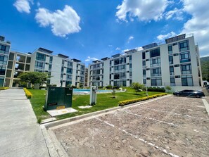 A modern multi-story building with a clear sky. - Apartment in El Chante Lake View (Chantepec)