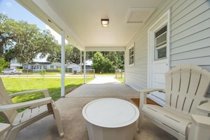 A covered porch with two white chairs and a small round table. - Orange Grove home - fully renovated minutes from downtown (St. Augustine)