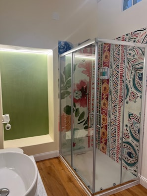 Un bagno con cabina doccia in vetro, un water e una vasca da bagno.