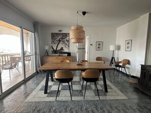 Ein moderner Essbereich mit einem großen Holztisch, zwei Stühlen und einer Hängeleuchte.