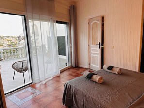 Una camera da letto con un letto, una porta e vista sull'esterno.