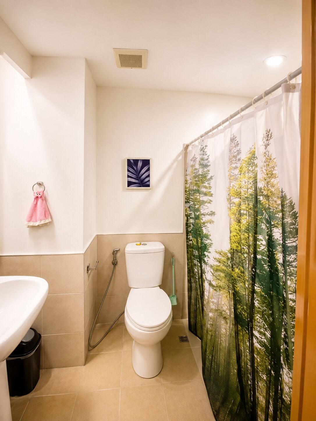 A bathroom with a toilet, sink, and shower curtain.