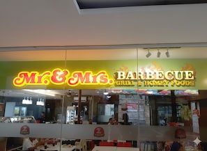 A restaurant named "Mr. & Mrs. Barbecue Grill & Honey Foods" with a neon sign, interior seating, and a counter with food items. - Near Sm And Ayala persimmon condo (Cebu City)
