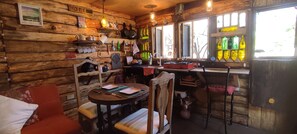 Een rustiek houten interieur met een eethoek, keukentrap en diverse keukengerei.