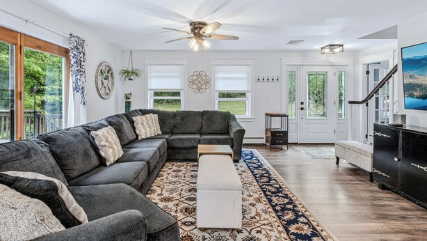 A modern living room with a sectional sofa, a wooden coffee table, and a patterned rug.