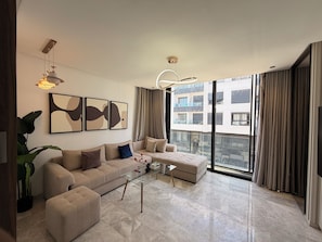 A modern living room with a sofa, coffee table, and abstract wall art. - Happy Living Maarif (Casablanca)