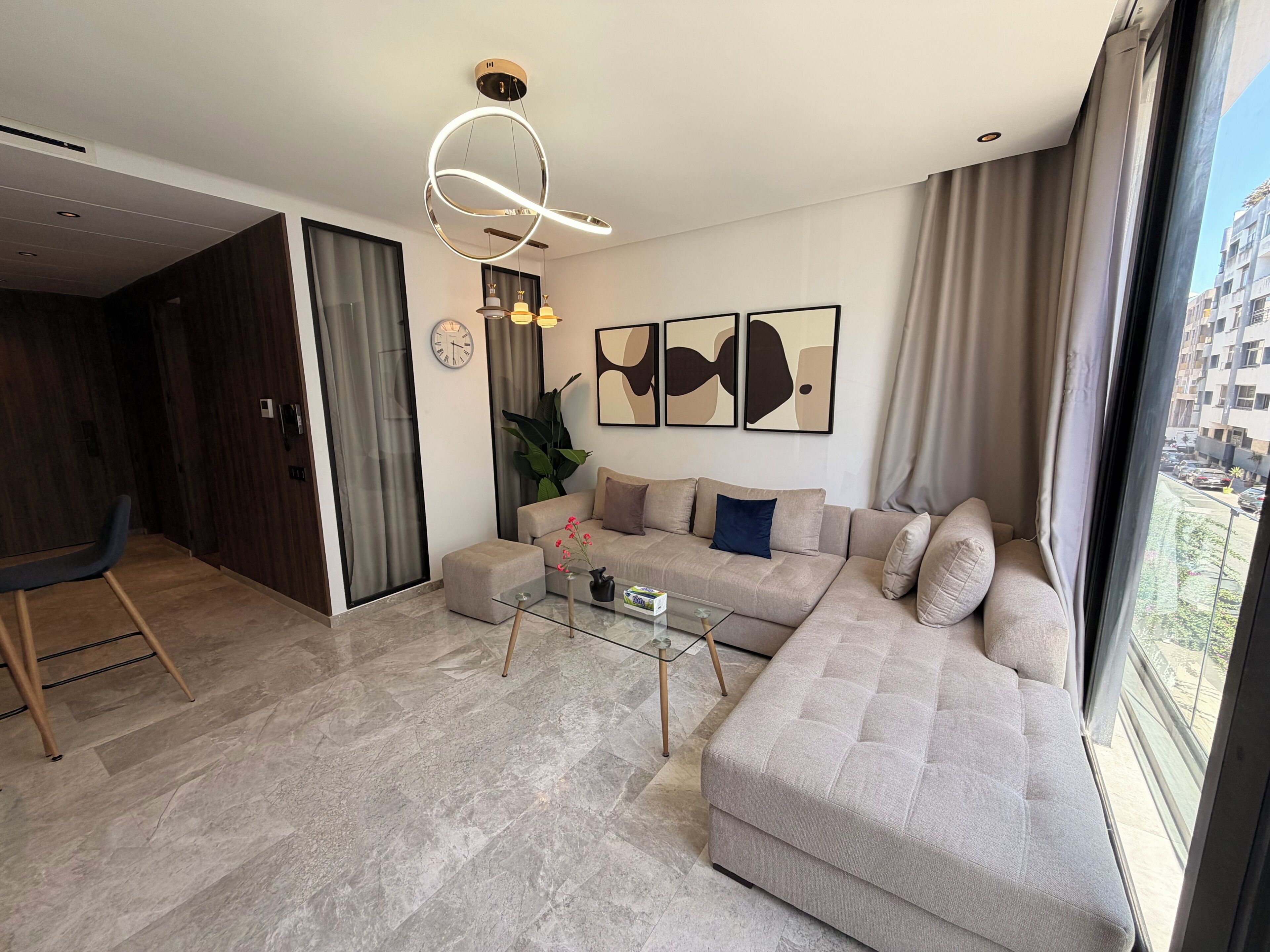 Una sala de estar moderna con un sofá modular, una mesa de centro de vidrio y arte abstracto en la pared.