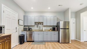 A modern kitchen with grey cabinets, stainless steel appliances, and a wooden floor. - Ponderosa Woods! Forest Hot Tub Escape by Monument (Monument)