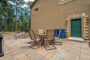 A patio with a table and chairs, a green door, and stone accents on the building.