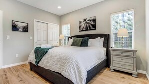A bedroom with a bed, nightstands, a window with blinds, and wall art. - Ponderosa Woods! Forest Hot Tub Escape by Monument (Monument)