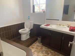 Un baño con inodoro, lavamanos y bañera.
