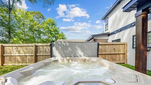 A hot tub in a backyard with a wooden fence and a house in the background. - Perfect Inlet Stay Minutes to MarshWalk & Water (Murrells Inlet)