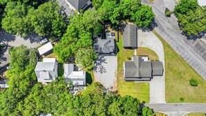 An aerial view of a residential area with multiple houses, a parking lot, and a road. - Perfect Inlet Stay Minutes to MarshWalk & Water (Murrells Inlet)