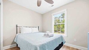 A bedroom with a bed, a window, and a ceiling fan. - Perfect Inlet Stay Minutes to MarshWalk & Water (Murrells Inlet)