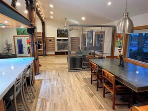 Cozinha moderna com área de bar, piso de madeira e vista para o exterior.