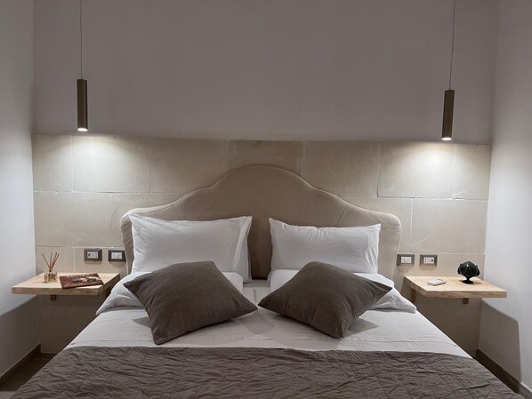 A modern hotel room with a large bed, two bedside tables, and a headboard. - Vrbo Property (Marina di Mancaversa)