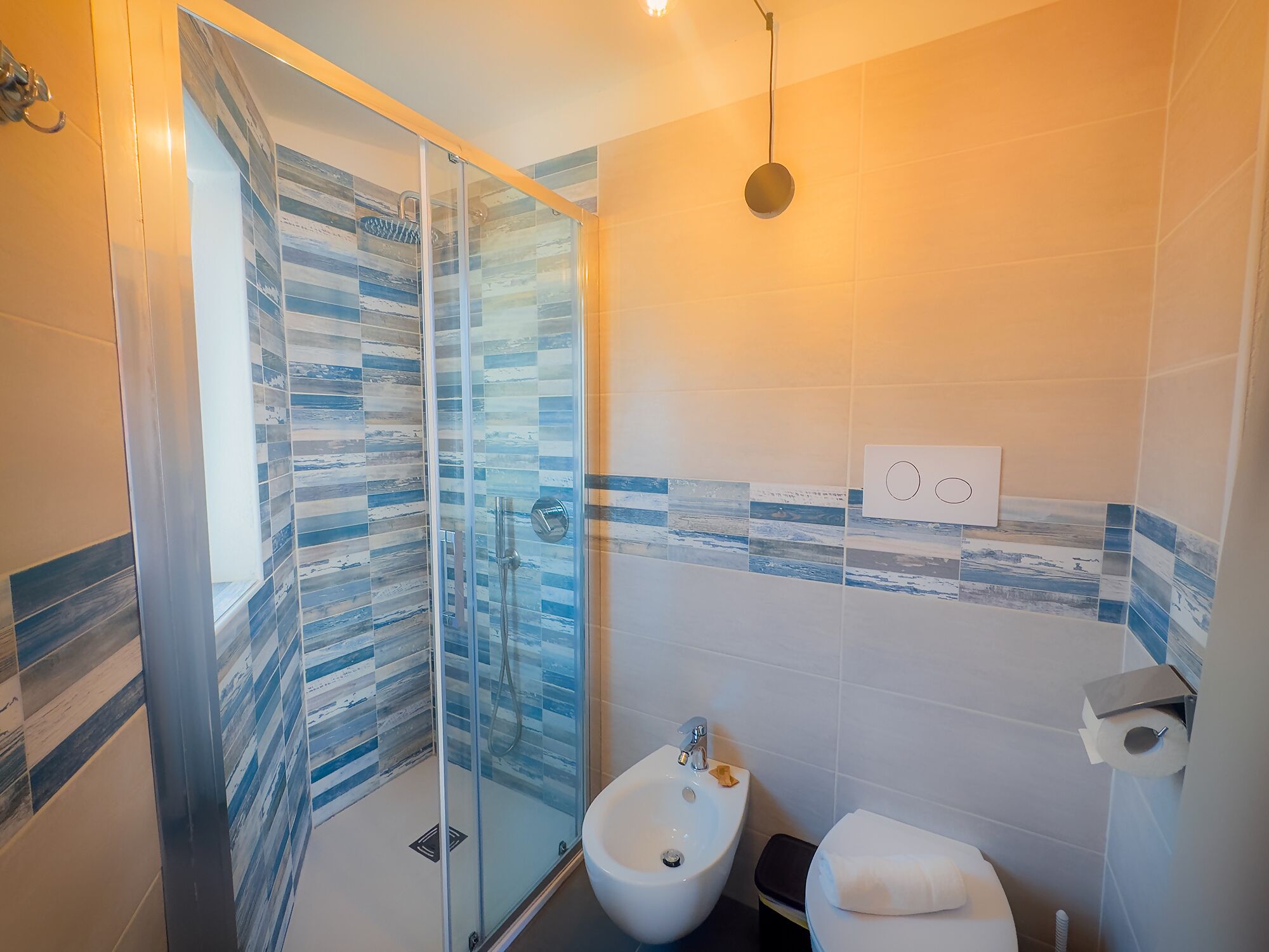 Une salle de bain avec une douche à parois de verre, un bidet et des toilettes.