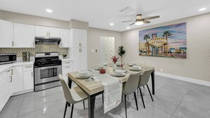 A modern kitchen with white cabinetry, a built-in microwave, and a stove. - The Sweet Home｜Central Located｜Perfect for Family (Las Vegas)