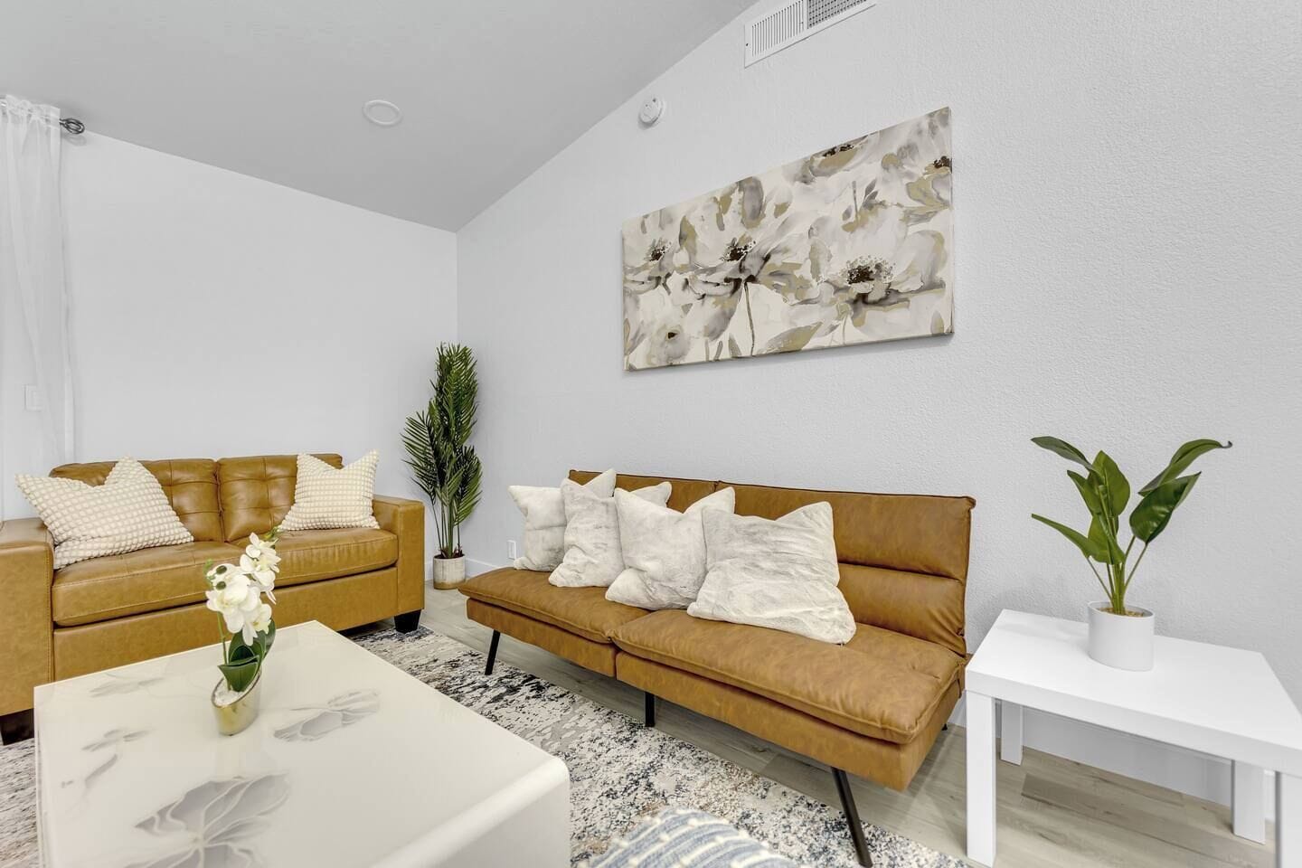 Ein modernes Wohnzimmer mit zwei Sofas, einem Couchtisch und einem Gemälde an der Wand.