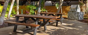 Outdoor picnic tables with a barbecue grill in the background. - 2-bedroom condo in tranquil Maui perfect for relaxing getaways (Maui)
