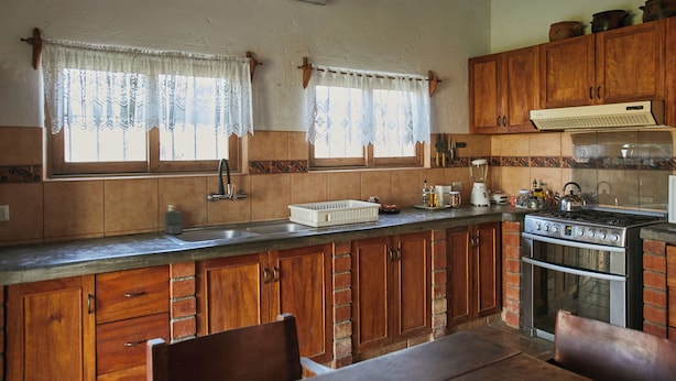 Una cocina con armarios de madera, estufa y lavaplatos.