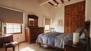 Un dormitorio con cama, cómoda, espejo y armario.