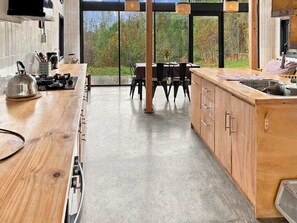 Una cocina moderna con encimera de madera, una mesa de comedor y vistas al exterior.
